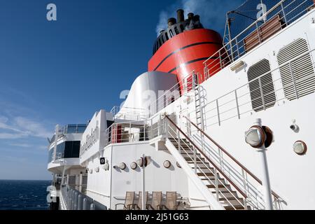 Blick vom Promenadendeck auf Cunards Luxuskreuzfahrtschiff, die RMS Queen Elizabeth, zeigt den riesigen roten Trichter Stockfoto