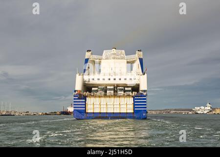 Brittany Ferries Fahrzeugfähre 'Mont St. Michel' nähert sich dem Hafen in Portsmouth, Hampshire, England. Mit Flugzeugträger der Marine im Hintergrund. Ansicht Stockfoto