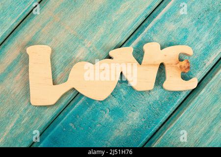 Wortliebe aus Holz; Foto auf Holzhintergrund einer anderen Farbe Stockfoto