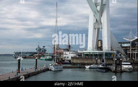 Der neue Flugzeugträger der britischen Marine, HMS Queen Elizabeth, vertäute in der Nähe von HMS Victory, Nelsons Schiff aus der Schlacht von Trafalgar von 1805, in Portsmouth Harb Stockfoto