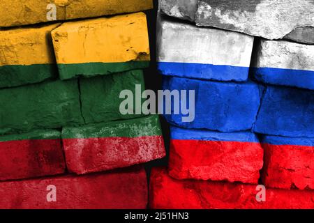 Konzept der Beziehung zwischen Litauen und Russland mit zwei bemalten Fahnen auf einer beschädigten Ziegelwand Stockfoto