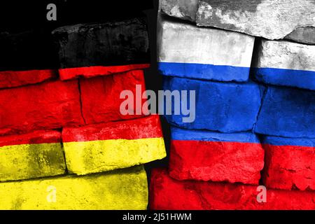 Konzept des Verhältnisses zwischen Deutschland und Russland mit zwei bemalten Fahnen auf einer beschädigten Ziegelwand Stockfoto