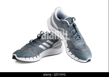 LONDON, Großbritannien - 19. APRIL 2022: Adidas Blue Sport Laufschuhe isoliert auf weißem Hintergrund. Adidas Sport Laufschuh. Modisch stylische Sportkasua Stockfoto