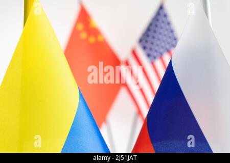 Staatsflagge von Russland und der Ukraine. China USA Flaggen auf dem Hintergrund. Russischer ukrainischer Kriegskonflikt Stockfoto