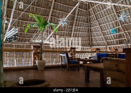 Holztische im Café unter einem Dach. Authentisches Interieur des Restaurants in Kendwa, Sansibar, Tansania. Stockfoto