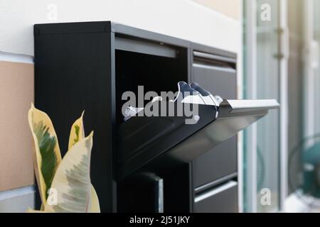 Schuhschrank aus Metall mit Schloss. Schwarze Schuhe Lagerung vor dem Haus. Stockfoto