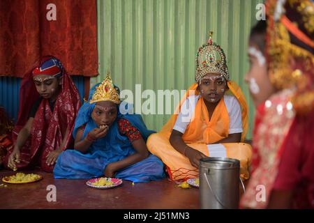 Folk-Künstler beim Mittagessen, bevor sie bei den Ritualen von Shiver Gajan, einem traditionellen hinduistischen Volksfest vor der Ernte am Stadtrand von Agartala, auftreten. Tripura, Indien. Stockfoto