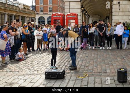 Straßenkünstler, der im April in Covent Garden, London, Großbritannien, für Menschenmengen auftrat Stockfoto