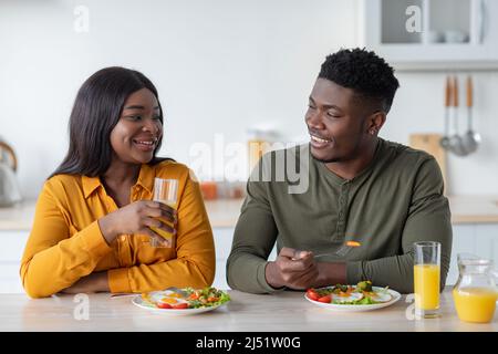 Portrait Von Lächelnden Jungen Schwarzen Liebhabern, Die Leckeres Frühstück In Der Küche Genießen Stockfoto