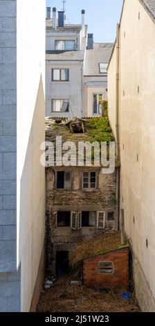 Lugo, Spanien - 16. April 2022: Alte Hausruine zwischen Neubauten in der Innenstadt von Lugo eingequetscht Stockfoto