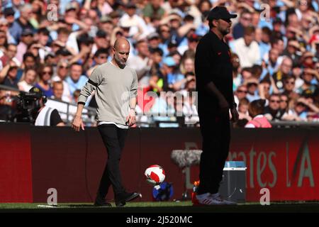 Der Manager von Manchester City, Pep Guardiola, spielt den Ball zurück als der Manager von Liverpool, Jurgen Klopp, schaut auf - Manchester City gegen Liverpool, das Halbfinale des Emirates FA Cup, Wembley Stadium, London - 16.. April 2022 nur für redaktionelle Verwendung Stockfoto
