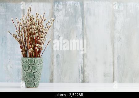 Haufen Kätzchen in blauer Keramikvase, Kopierraum. Stockfoto