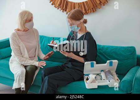 Junge Ärztin, die zu Hause eine ärztliche Beratung durchführt Stockfoto