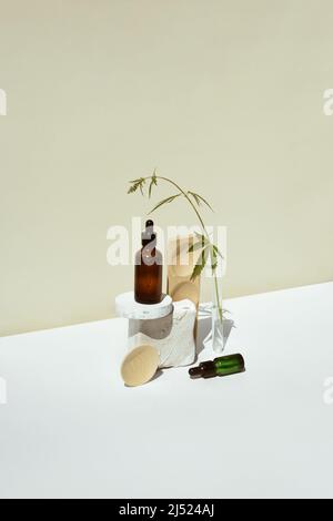 CBD-Öl in einer Pipette und einer offenen Flasche auf einem Podium mit einem Blatt Marihuana, Hanf. Minimalistisches Produktkonzept, Cannabidiolöle, trendige Styli Stockfoto