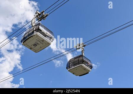 Koblenz, Deutschland - April 2022: Seilbahnen bringen Besucher zur Festung Ehrenbreitstein, die auf einem Hügel über dem Rhein thront. Stockfoto