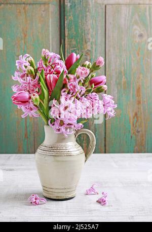 Floristin bei der Arbeit: Frau zeigt, wie man Frühlingsstrauß mit Tulpe, Hyazinthe und Nelkenblumen zu machen. Schritt für Schritt, Tutorial. Stockfoto