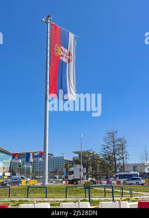 Belgrad, Serbien - 13. April 2022: Sehr große serbische Flagge auf dem Tall Pole Nikola Tesla Airport in Surcin. Stockfoto