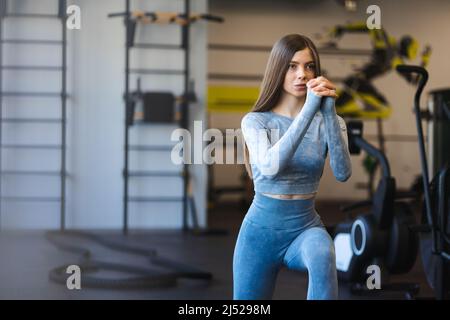 Junge Fitness-Frau macht Ausfallschritte während des Trainings im Fitnessstudio Stockfoto