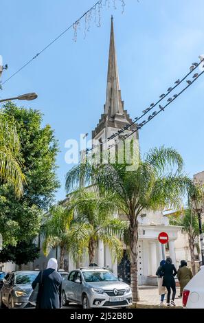 Stadtzentrum Platz im Stadtzentrum von Birkhadem. Menschen, Autos, Taubenvögel auf Stromleitungen und fliegenden, sich ausbreitenden Flügeln. Gebäude mit alter Kirchenarchitektur. Stockfoto