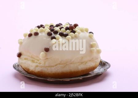 Ein Donut aus weißer Schokolade auf einem rosa Hintergrund. Party-Dessert Stockfoto