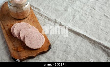 Hausgemachter Jagdwurst auf rustikalem Holzbrett, Seitenansicht. Speicherplatz kopieren. Stockfoto