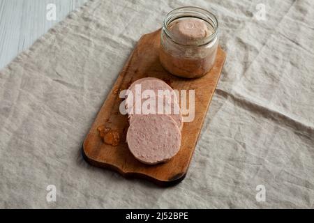 Hausgemachter Jagdwurst auf rustikalem Holzbrett, Seitenansicht. Stockfoto