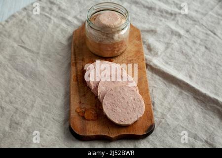 Hausgemachter Jagdwurst auf rustikalem Holzbrett, Seitenansicht. Stockfoto