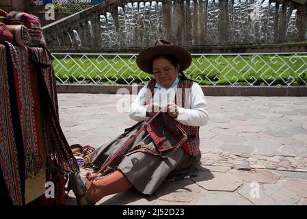 Alte Dame, die traditionelle Wolle in traditioneller Kleidung webt Stockfoto