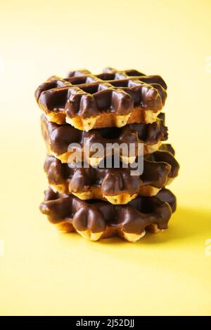 Stapel Schokoladenwaffeln. Nahaufnahme und gelber Hintergrund, Kopierbereich. Stockfoto