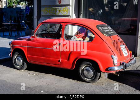 Bukarest, Rumänien, 25. September 2021: Ein lebhaft roter kleiner Fiat-Oldtimer, der in einer Straße im Stadtzentrum geparkt ist Stockfoto