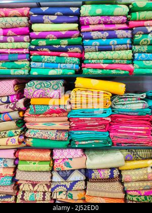 Stoffrollen und Textilien im Geschäft. Mehrfarbige indische Muster auf dem Markt Stoffe in Rollen. Stoffgeschäft in Pune, Maharashtra, Indien. Stockfoto