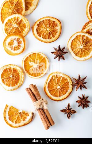 Getrocknete Orange in Scheiben geschnitten mit Zimtstangen und Anissternen auf weißem Hintergrund. Draufsicht. Stockfoto