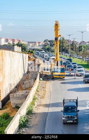 Verkehrsstaus auf der Nationalstraße RN1 wegen eines LKW-Fahrzeugkrans für Baumaschinen, der auf der Seite einer Brückenbaustelle geparkt ist. Stockfoto