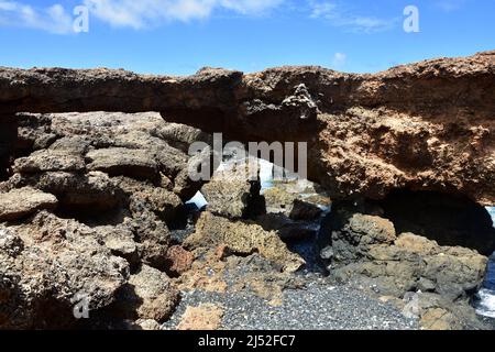 Landschaftlich reizvolle, natürliche, gewölbte Felsbrücke an der Küste von Aruba. Stockfoto