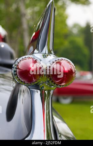 Nahaufnahme einer Heckflosse und Lichter an einem restaurierten Oldtimer, das auf einer Sommer-Autolampe zu sehen ist. Stockfoto