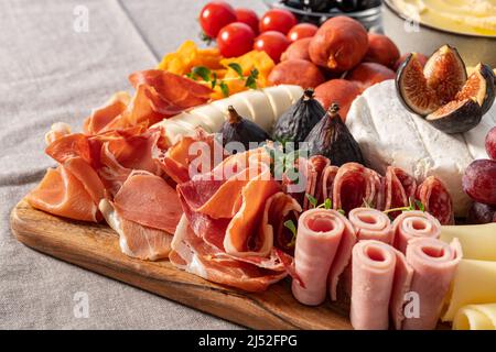 Die Aufspannung von Käse und Meze ist reich an verschiedenen Früchten, Käse, Fleisch und Crackern Stockfoto