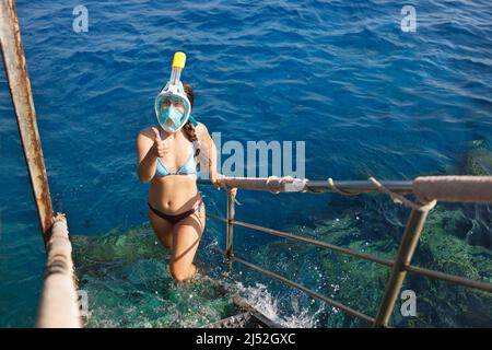 Junge Frau mit Vollgesichtsmaske zum Schnorcheln Stockfoto