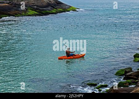 RIO DE JANEIRO, BRASILIEN - 14. NOVEMBER 2015: Mann im Kanu paddelt zum Strand Barra da Tijuca Stockfoto