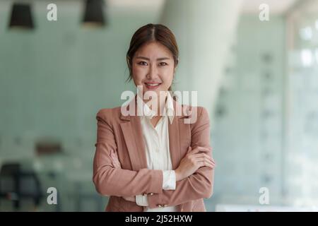 Schöne asiatische Geschäftsfrau, die sich das pädagogische Webinar auf einem Laptop ansieht. Finanzierungskonzept. Stockfoto