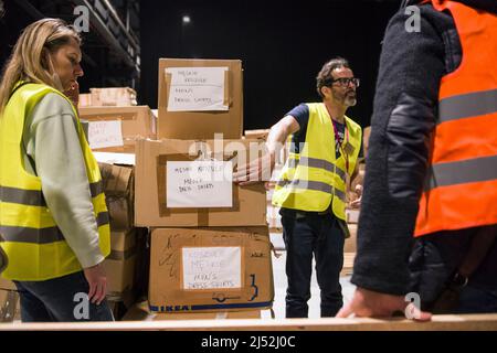 Warschau, Polen. 19. April 2022. Freiwillige werden neben Hilfsgütern im Flüchtlingszentrum der Global Expo in Warschau gesehen. Nach Schätzungen des UNHCR, der UN-Flüchtlingsorganisation, sind seit dem Einmarsch Russlands in die Ukraine am 24.. Februar fünf Millionen Ukrainer abgereist. Fast drei Millionen Menschen haben von der Ukraine aus die polnische Grenze überschritten. In Warschau sind immer noch Tausende von Menschen im Aufnahmezentrum der Global Expo für Flüchtlinge untergebracht - einem von vielen und zweitgrößten Flüchtlingsunterkünften in der Hauptstadt. (Foto von Attila Husejnow/SOPA Images/Sipa USA) Quelle: SIPA USA/Alamy Live News Stockfoto