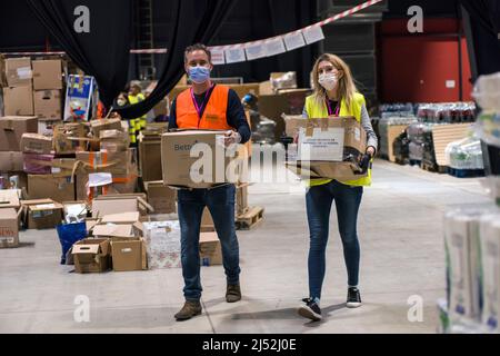 Warschau, Polen. 19. April 2022. Freiwillige tragen Hilfsgüter im Flüchtlingszentrum der Global Expo in Warschau. Nach Schätzungen des UNHCR, der UN-Flüchtlingsorganisation, sind seit dem Einmarsch Russlands in die Ukraine am 24.. Februar fünf Millionen Ukrainer abgereist. Fast drei Millionen Menschen haben von der Ukraine aus die polnische Grenze überschritten. In Warschau sind immer noch Tausende von Menschen im Aufnahmezentrum der Global Expo für Flüchtlinge untergebracht - einem von vielen und zweitgrößten Flüchtlingsunterkünften in der Hauptstadt. (Foto von Attila Husejnow/SOPA Images/Sipa USA) Quelle: SIPA USA/Alamy Live News Stockfoto