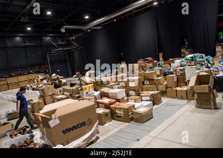 Warschau, Polen. 19. April 2022. Im Flüchtlingsaufnahmezentrum der Global Expo in Warschau sind zahlreiche Kisten mit Spenden zu sehen. Nach Schätzungen des UNHCR, der UN-Flüchtlingsorganisation, sind seit dem Einmarsch Russlands in die Ukraine am 24.. Februar fünf Millionen Ukrainer abgereist. Fast drei Millionen Menschen haben von der Ukraine aus die polnische Grenze überschritten. In Warschau sind immer noch Tausende von Menschen im Aufnahmezentrum der Global Expo für Flüchtlinge untergebracht - einem von vielen und zweitgrößten Flüchtlingsunterkünften in der Hauptstadt. (Foto von Attila Husejnow/SOPA Images/Sipa USA) Quelle: SIPA USA/Alamy Live News Stockfoto
