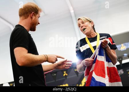 Der Herzog von Sussex spricht mit einem britischen Konkurrenten während des Schwimmens bei den Invictus Games in Het Hofbad Den Haag, Niederlande. Bilddatum: Dienstag, 19. April 2022. Stockfoto