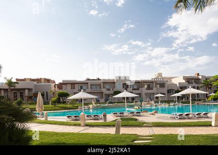 Hurghada, Ägypten - 1. Oktober 2019: Sonnenschirme und Sonnenliegen in der Nähe des Pools im Jaz Casa Del Mar Resort in Hurghada, Ägypten Stockfoto