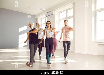 Eine Gruppe von glücklichen jungen Menschen, die gemeinsam Sport treiben, während sie im Fitnessstudio trainieren. Stockfoto