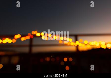 Außerhalb des Fokus weihnachtslichter auf dem Geländer eines Balkons in der Nacht Stockfoto