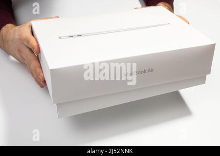 Saratov, Russland - 26. Februar 2022: Auspacken des neuen modernen Macbook Air 13 Zoll mit M1 Prozessor aus stilvoller Verpackung Nahaufnahme, weißer Hintergrund Stockfoto