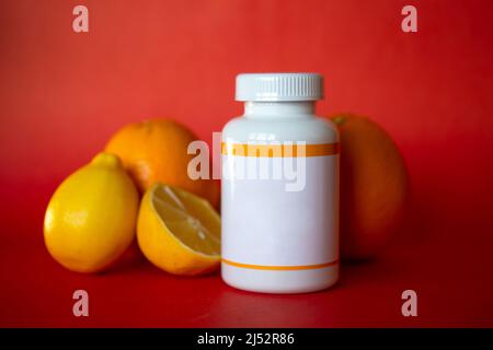 Weißes Plastikglas mit Orangen auf rotem Hintergrund Stockfoto