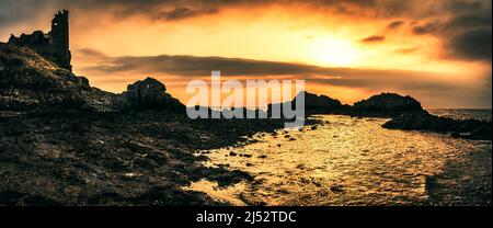 Ruinen von Dunure Castle am felsigen Strand bei Sonnenuntergang, South Ayrshire, Schottland, Großbritannien Stockfoto