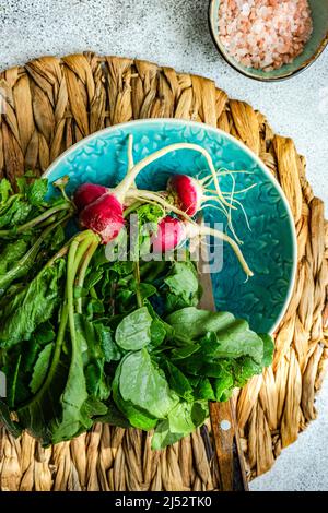 Ansicht von oben auf einer Platte mit frischen Radieschen mit rosa Himalaya-Salz Stockfoto
